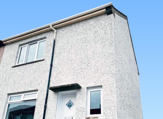 Roughcast finish on a house corner and gutter detail