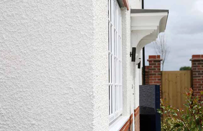 Close-up of a smooth white render finish beside a window